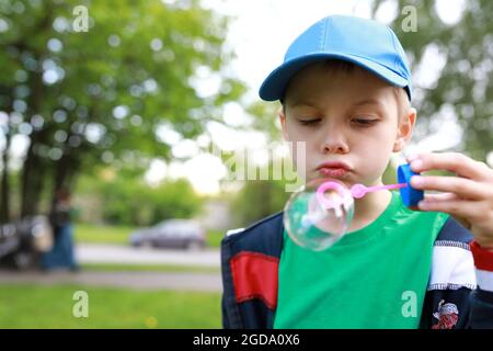 Boy blowing soap bubbles in the park Stock Photo