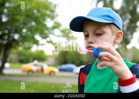 Child blowing soap bubbles in the park Stock Photo