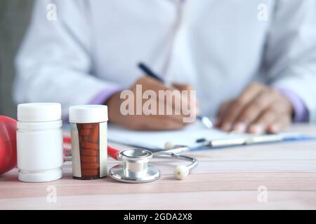 doctor hand writing prescription on desk, close up. Stock Photo