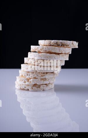 rice cakes by a column, on a white table and a black background. Stock Photo