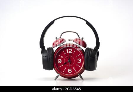 Red Alarm Clock put on headphones Stock Photo