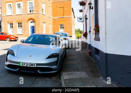 Woodbridge Suffolk UK August 11 2021: A 2021 model electric Porsche Taycan Turbo parked on the road outside a popular hotel in the market town of Wood Stock Photo