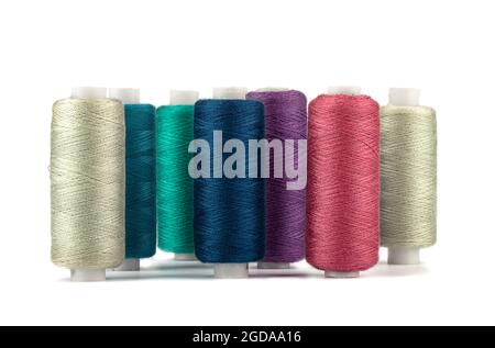 Rows of spools of thread of different colors on a white background. Copy space. Stock Photo