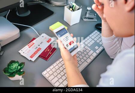 Worried woman looking denied covid health passport on mobile while booking a trip Stock Photo
