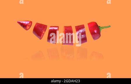 flying red pepper on orange background Stock Photo
