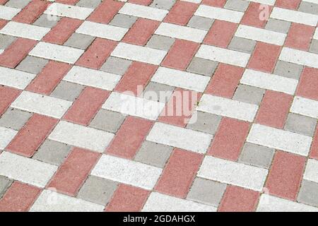 Concrete or paved newly laid gray and red paving slabs or stones for floors or walkways. Concrete paving slabs in the backyard or road paving. Garden Stock Photo