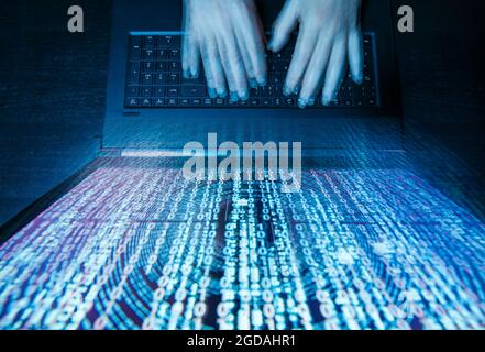 Hacker with computer and matrix on monitor Stock Photo