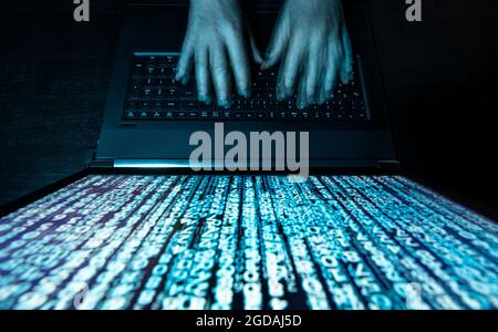 Hacker with computer and matrix on monitor Stock Photo
