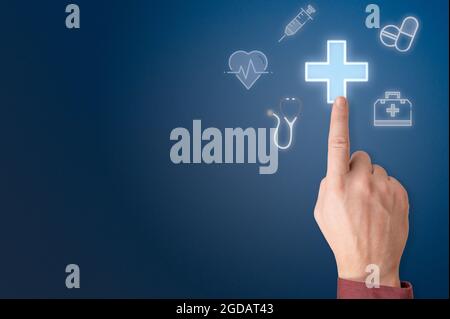 hand points to sign of medical cross. man hand touching first aid sign on virtual screen. businessman pressing virtual button on medical touchscreen. Stock Photo