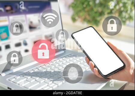 mockup cellphone. businesswoman hold cell phone. woman logging in laptop and holding smartphone on hand with security key lock icon on screen. Privacy Stock Photo