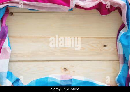 Checkered fabric on wood table background. Stock Photo