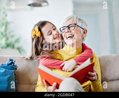 grandchild granddaughter grandma grandmother reading book girl senior Stock Photo