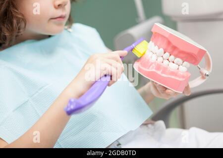 Cropped shot of an unrecognizable boy learning brushing teeth on jaw model with big toothbrush at dental clinic Stock Photo