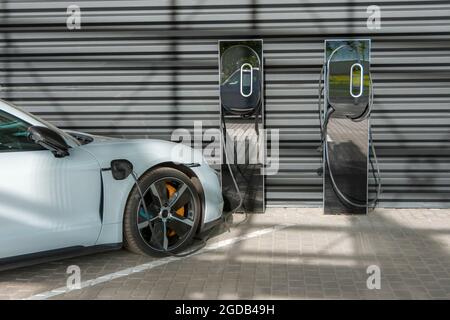 Passenger car near the garage next two battery charging stations Stock Photo