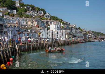 Looe, Cornwall, England, UK. 2021. West Looe a popular holiday resort and fishing centre in Cornwall, UK, passenger ferry crossing River Looe on incom Stock Photo