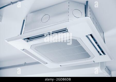 Commercial Ceiling Cassette Air Conditioners setup in office without ceiling sheet blue clean colortone. Stock Photo