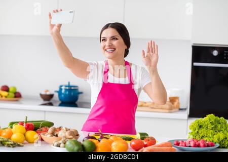 Photo of funny brunette millennial lady talk telephone cook from home at table kitchen Stock Photo