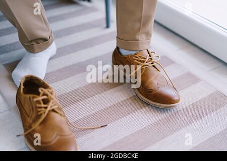 Groom sits on a chair in unlaced shoes. Close-up Stock Photo