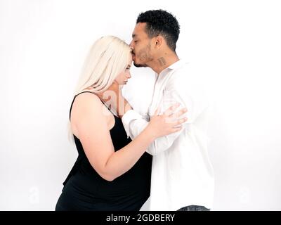 Profile view of a stylish and happy multi-ethnic couple expecting a baby Stock Photo