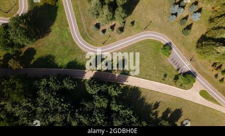 A winding bike path in the park. Winds among trees and bushes. Aerial photography. Stock Photo