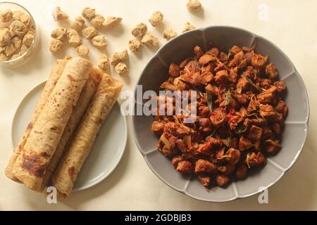 Dry roasted soya chunks with onions tomatoes and spices. Prepared with Kerala style meat masala in coconut oil. Served with indian flatbread. Shot on Stock Photo