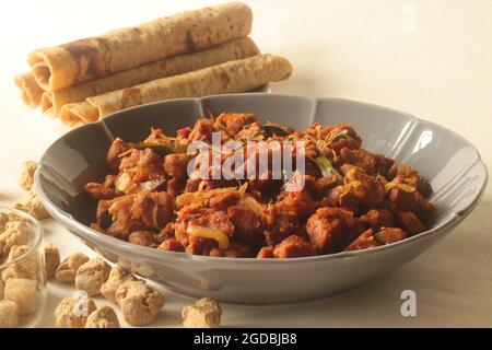 Dry roasted soya chunks with onions tomatoes and spices. Prepared with Kerala style meat masala in coconut oil. Served with indian flatbread. Shot on Stock Photo