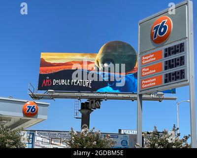 FX billboard over 76 gas station sign with prices in Los Angeles, CA Stock Photo