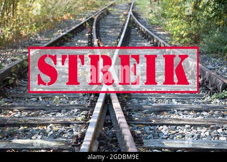 German text banner Streik (meaning strike) over old railway tracks, selected focus Stock Photo