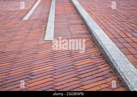 Steps separated by a gray border, consisting of brown and orange rectangular floor tiles, extending into the distance in the perspective, shot with se Stock Photo