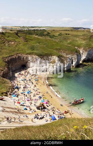 Yorkshire beach; people sunbathing on a hot sunny day in summer, Flamborough beach, Flamborough, East Yorkshire England UK Stock Photo