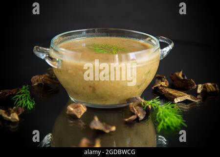 hot homemade vegetable vegetarian soup with dried mushrooms in a glass bowl on black background Stock Photo