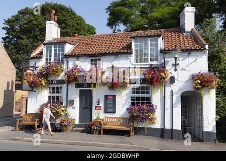 England pub; The Barrel, a traditional english pub decked with colourful flowers in hanging baskets, Walkington, Beverley Yorkshire UK Stock Photo