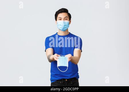 Different emotions, social distancing, self-quarantine on coronavirus and lifestyle concept. Handsome asian male volunteer, guy in personal protective Stock Photo