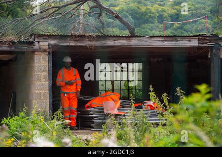 Wendover, Buckinghamshire, UK. 10th August, 2021. HS2 security on guard in the old farm buildings at Road Barn Farm site just outside Wendover. Credit: Maureen McLean/Alamy Stock Photo