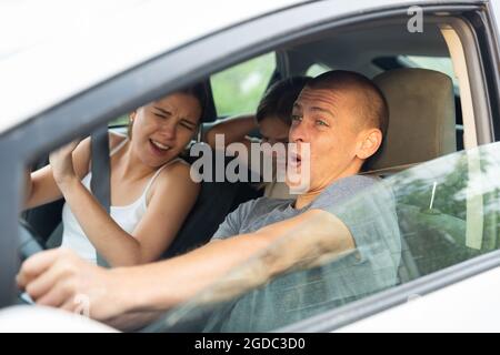 Man driver, his wife and doughter scared screaming in the car Stock Photo