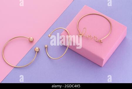 Three modern golden bracelets on pastel colors geometric background Stock Photo