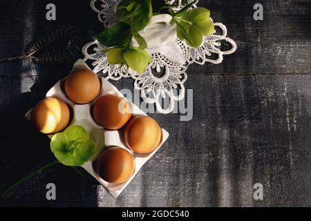 fresh eggs in a white ceramic tray on a wooden rustic table. raw brown eggs in a reusable porcelain stand. Copy space. Top view. Stock Photo