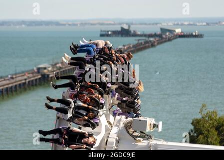 Thrill riders on Axis ride on seafront theme park of Southend on Sea, Essex, UK, as England opens up after lockdown. High view over seaside Stock Photo