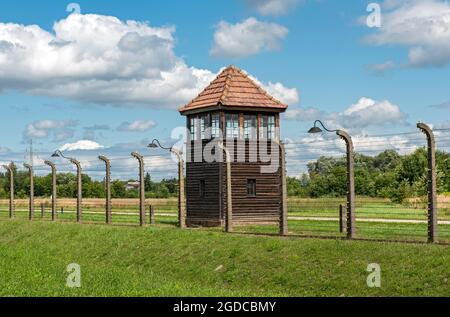Barbed-wire fence and guard tower at Auschwitz II-Birkenau concentration camp, Oswiecim, Poland Stock Photo