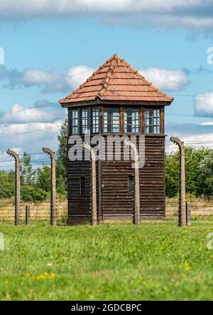 Barbed-wire fence and guard tower at Auschwitz II-Birkenau concentration camp, Oswiecim, Poland Stock Photo
