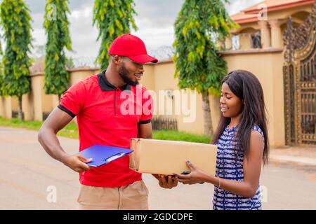 african delivery worker delivers a package to a woman Stock Photo