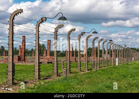 Barbed-wire fence and lamp-post at Auschwitz II-Birkenau concentration camp, Oswiecim, Poland Stock Photo