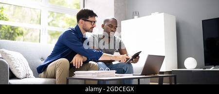 Happy Gay Couple Doing Taxes And Income Planning With Calculator Stock Photo