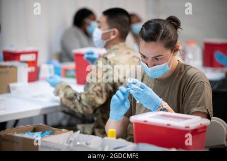 U.S. Air Force Staff Sgt. Santana Sanborn, an aerospace medic deployed from Buckley Air Force Base, Colorado, prepares a vaccine at the Tampa Community Vaccination Center in Tampa, Florida, March 5, 2021. Sanborn works throughout the day to transfer the vaccines from storage vials into syringes as needed. U.S. Northern Command, through U.S. Army North, remains committed to providing continued, flexible Department of Defense support to the Federal Emergency Management Agency as part of the whole-of-government response to COVID-19. (U.S. Air Force photo by Master Sgt. Holly Roberts-Davis/56 Figh Stock Photo
