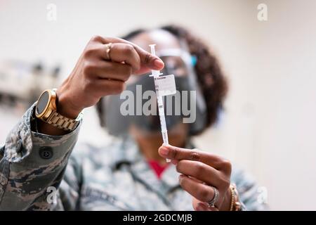 Master Sgt. Nicole Jacocks, 413th Aeromedical Staging Squadron NCO in charge of the immunizations clinic, examines a COVID-19 vaccine March 6, 2021, at Robins Air Force Base, Georgia. During their March unit training assembly, the 413th ASTS administered 92 vaccines. Next month, they will give out second doses to those 92 people. (U.S. Air Force photo by Jamal D. Sutter) Stock Photo