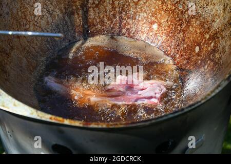 Pieces of raw lamb fat dumba are fried in a black cauldron, cooking food  Stock Photo - Alamy