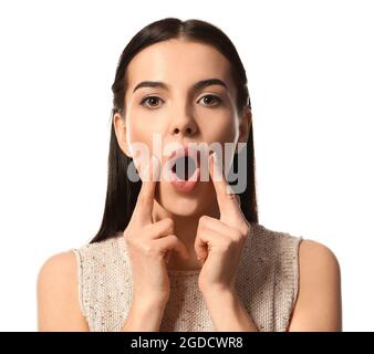 Young woman doing face building exercise against white background Stock Photo