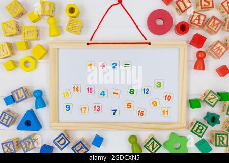 Multicolored fractions, blocks on white wooden table. Back to school, fun math, games for kindergarten, preschool education. Stock Photo