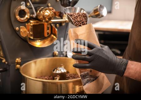 Man packaging coffee beans after roasting Stock Photo