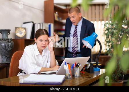 Dissatisfied manager scolding frustrated female assistant Stock Photo